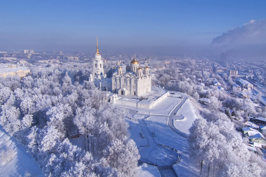 A view to a big white cathedral with golden domes from the bird-eye view in winter.