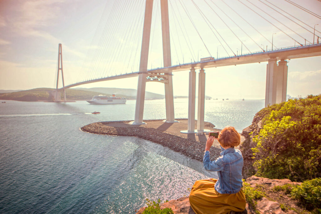 A lady taking photo of a cable-stayed bridge
