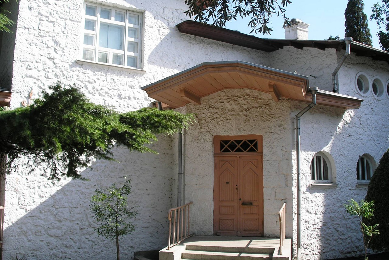 An entrance to a house built of stone painted in white