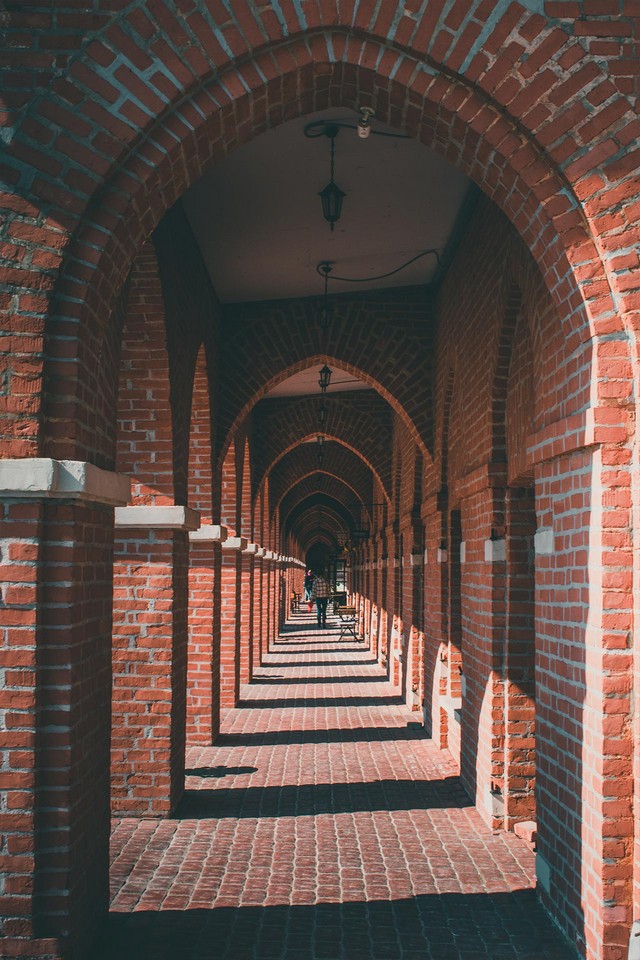 A portico of red brick building consisting of roofed arcades