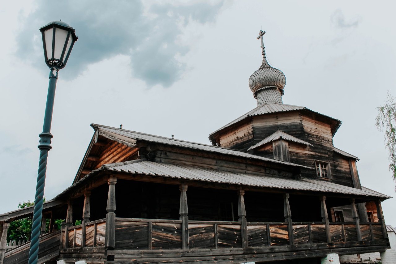 A little wooden church looking like a house with terrace and wooden dome