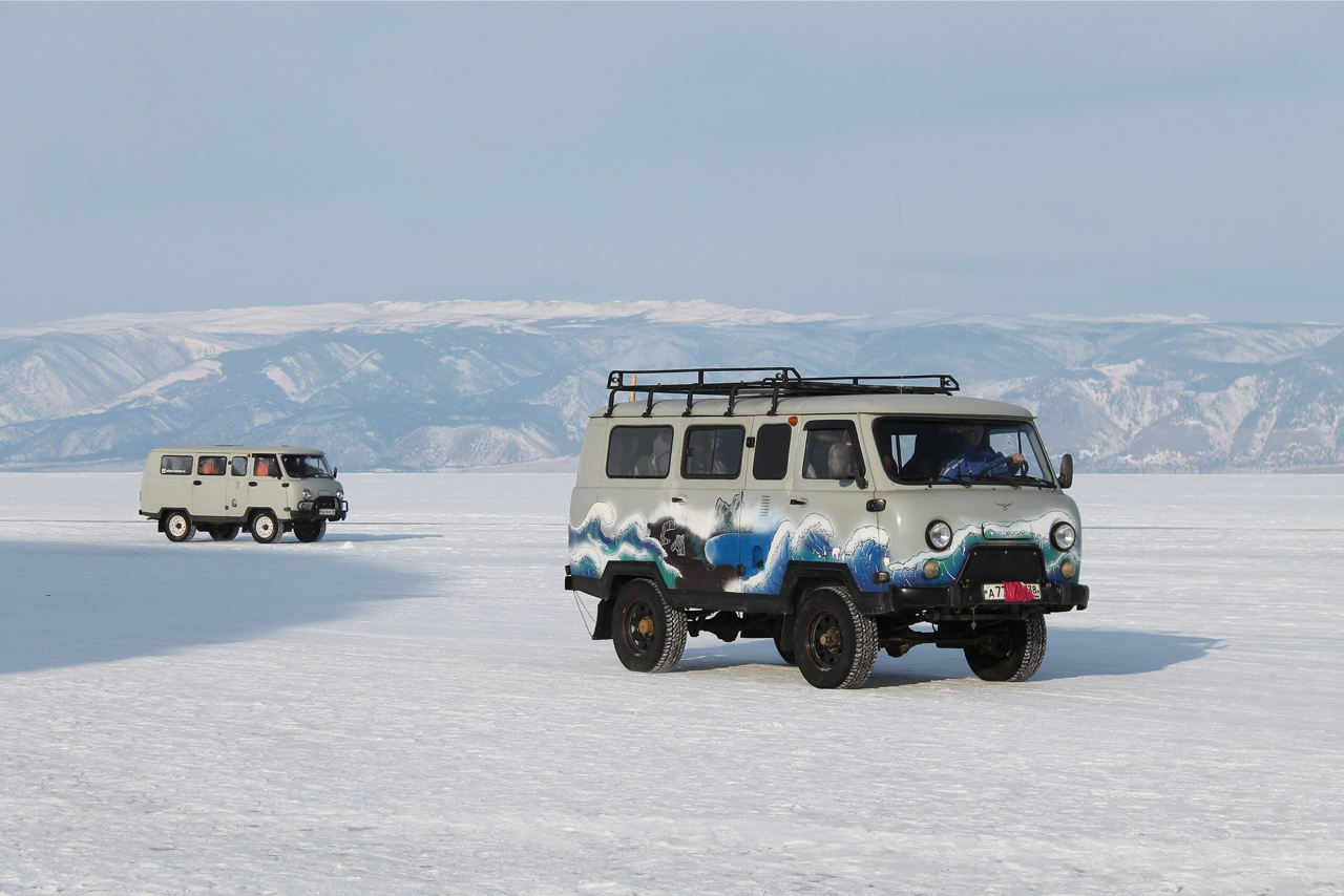 UAZ vans on the frozen lake covered with snow, UAZ van with sea painted on it