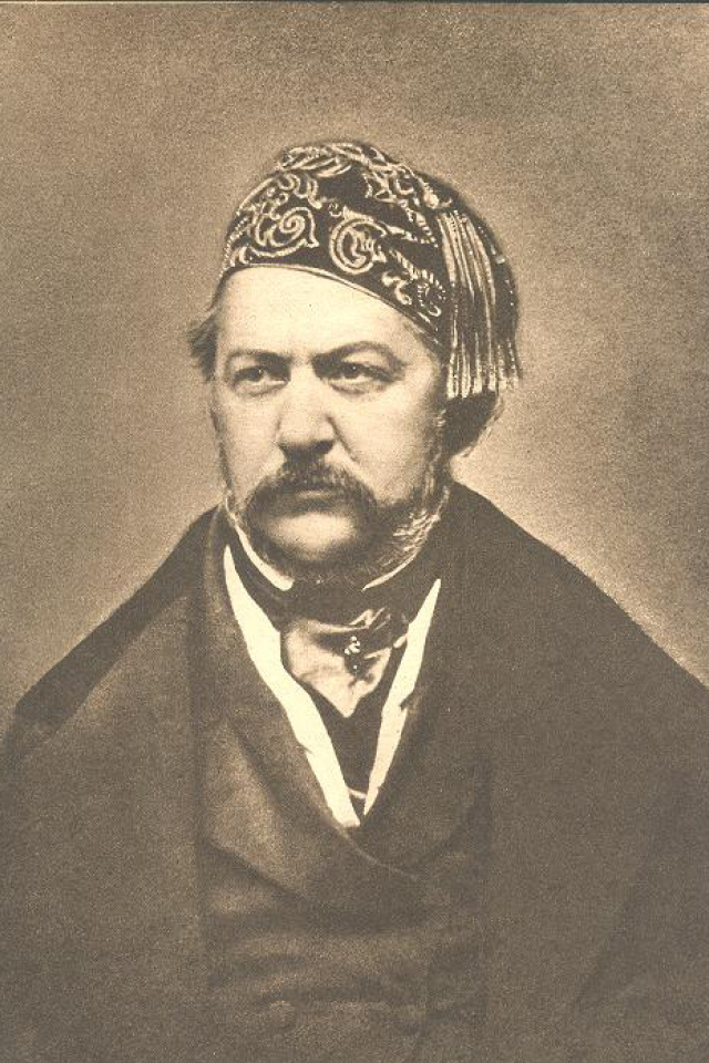 A black and white portrait of a man from 19th century wearing an oriental hat