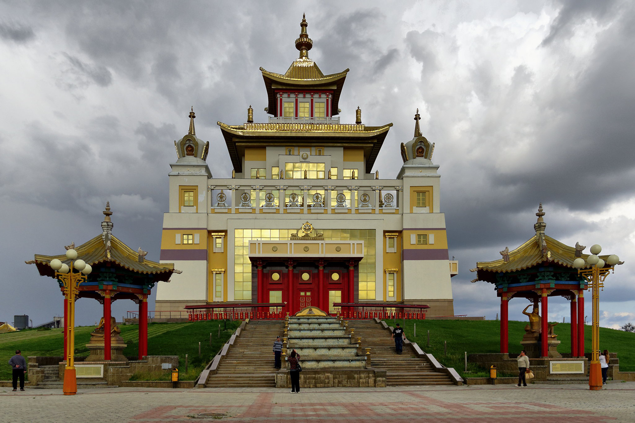 A modern Buddhist temple of white and golden colors, stairs in front of the temple