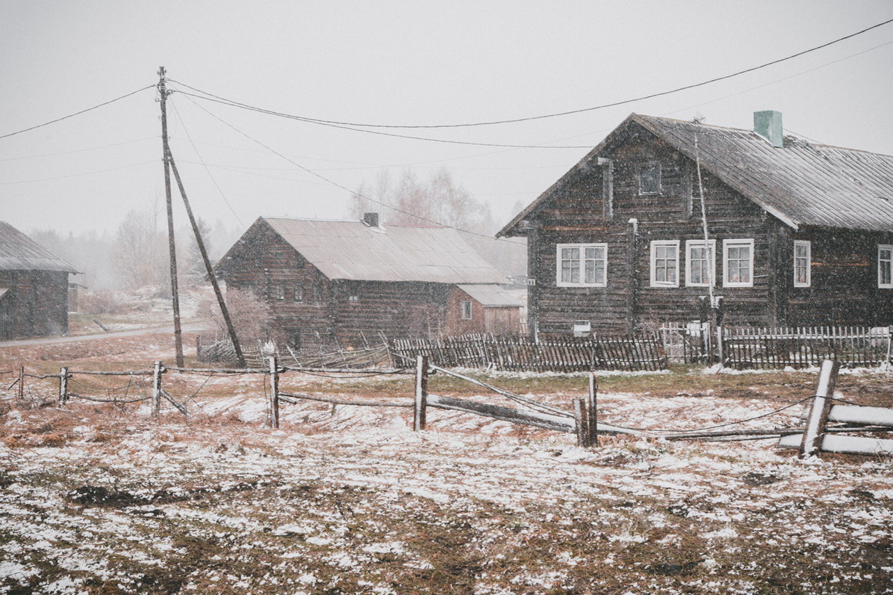 Old wooden country houses in winter, beginning of winter, snow in the countryside