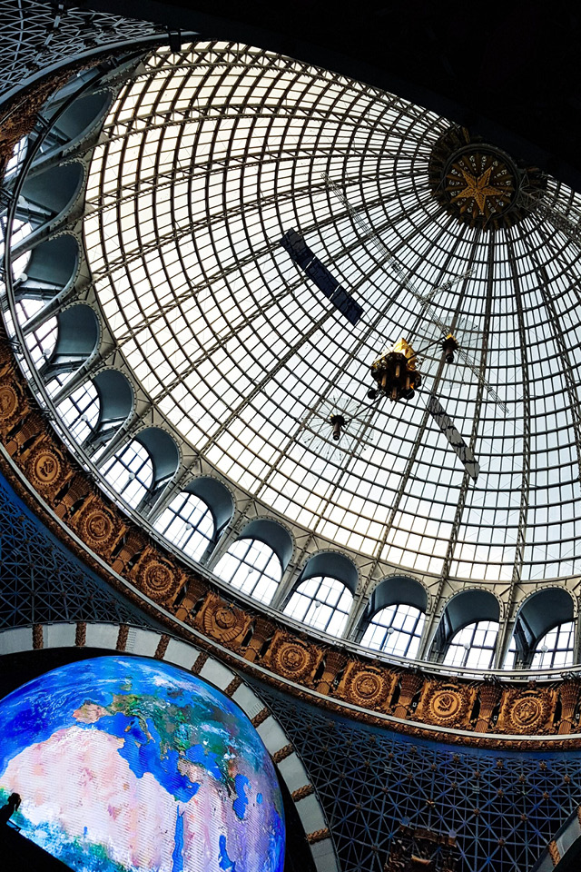 A glass dome with a satellite under the cupola, soviet symbolic around the dome, a giant world globe