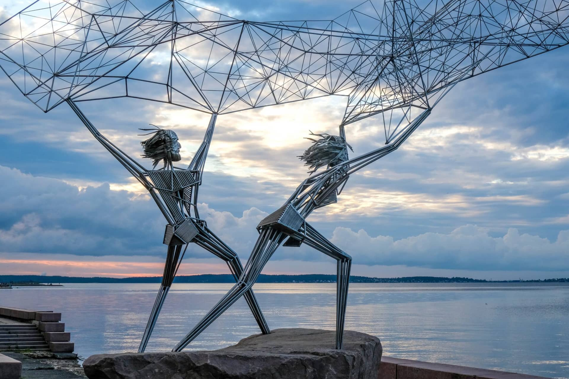 A modern steel monument of two fishers throwing their net into the lake.