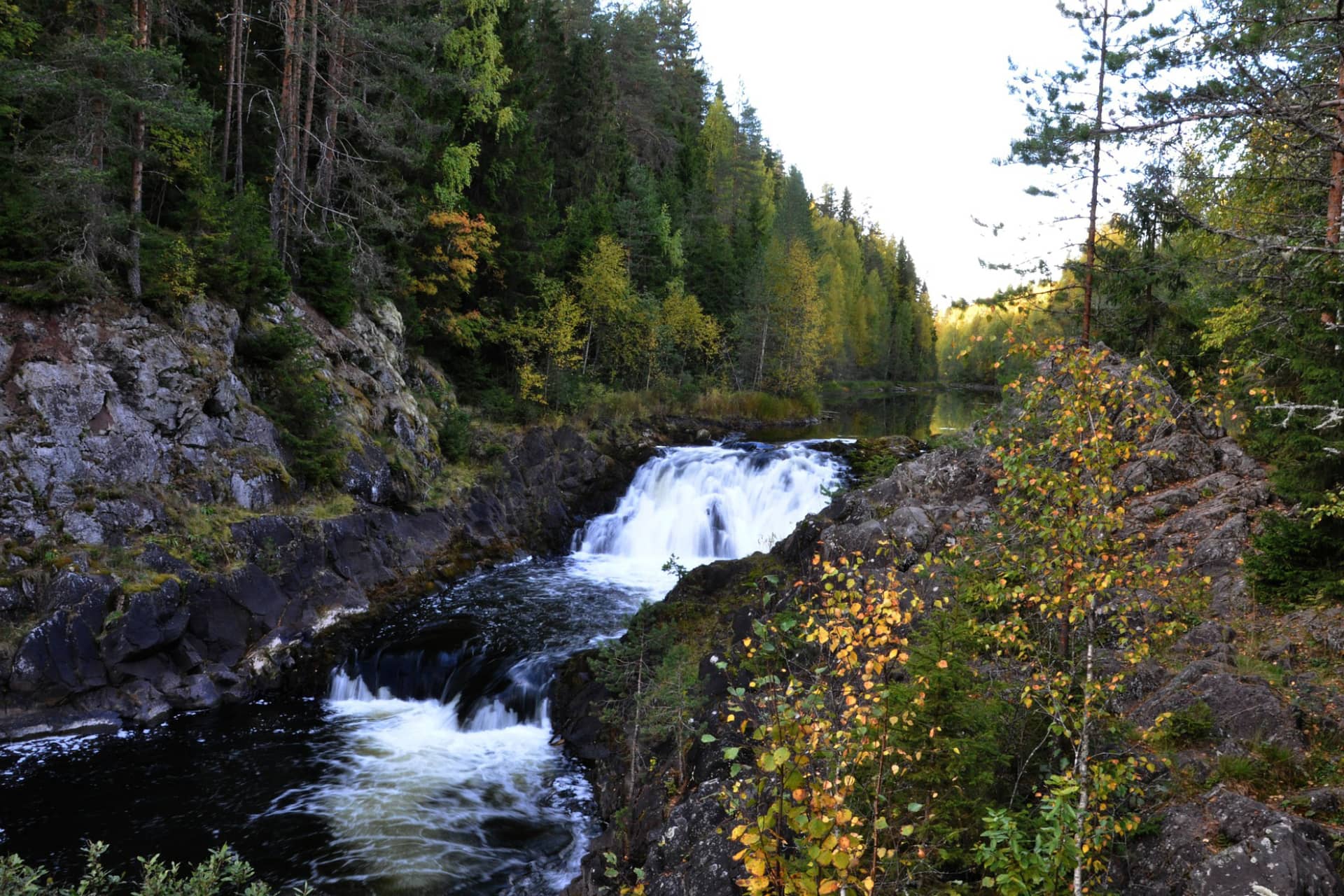 A waterfall surrounded with taiga forest