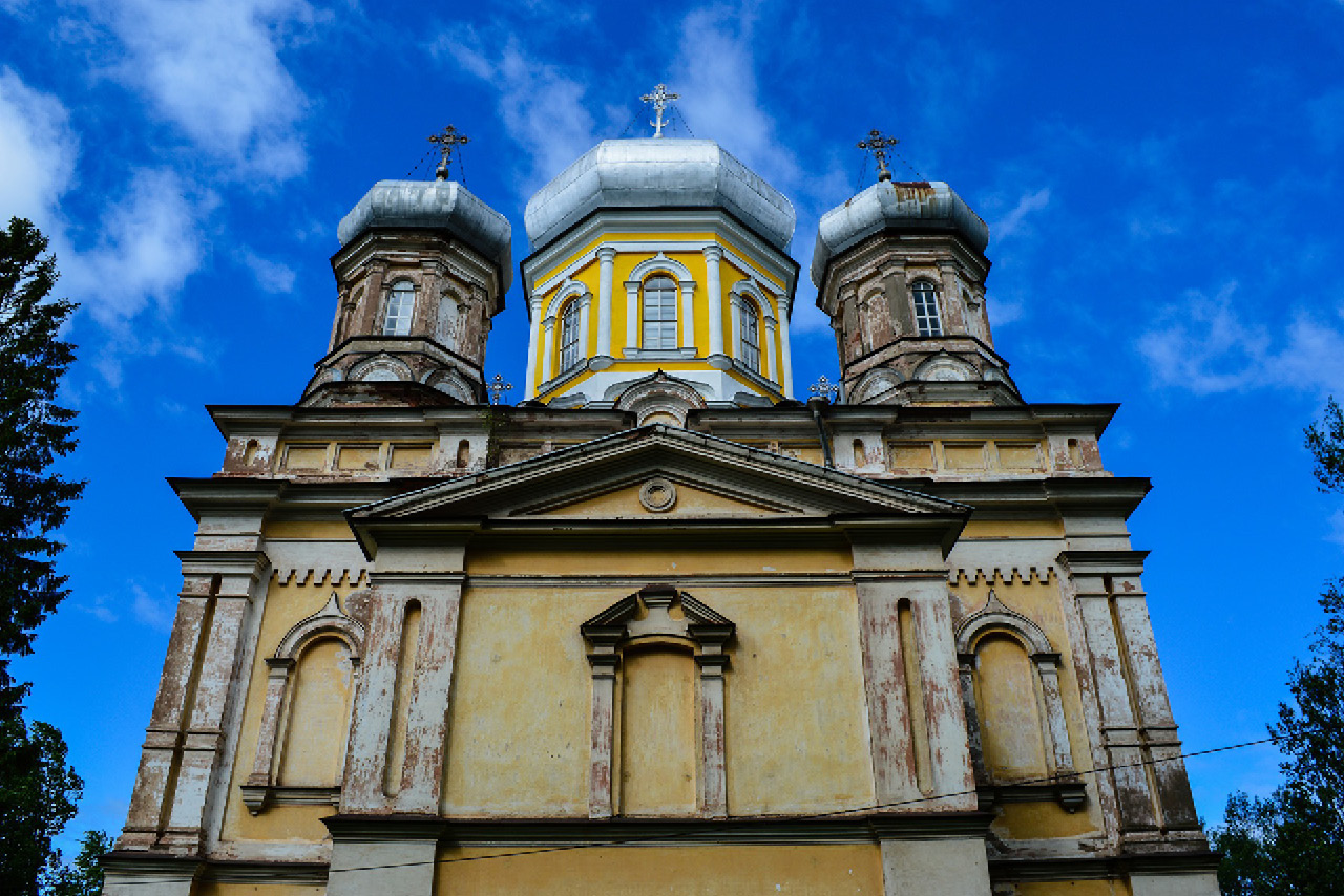 Three domes of an old church, a renovated yellow dome in the middle and other two smaller domes