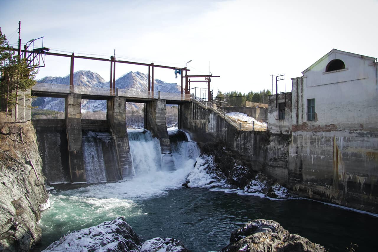 An old hydroelectric station and mountains in the background