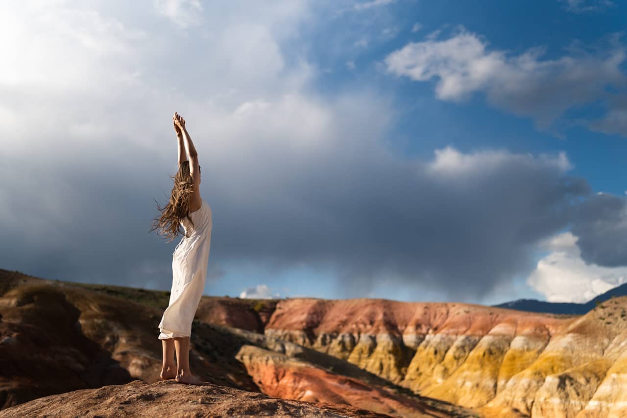 A young woman doing yoga in front of the beautiful mountains