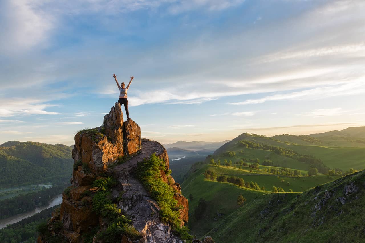 A human at the top of a rock of unusual shape, beautiful landscape in mountains