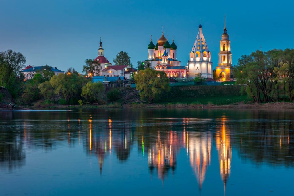 A beautiful ancient Russian city on a bank of a river at night, monastery consisting of several churches and bell towers