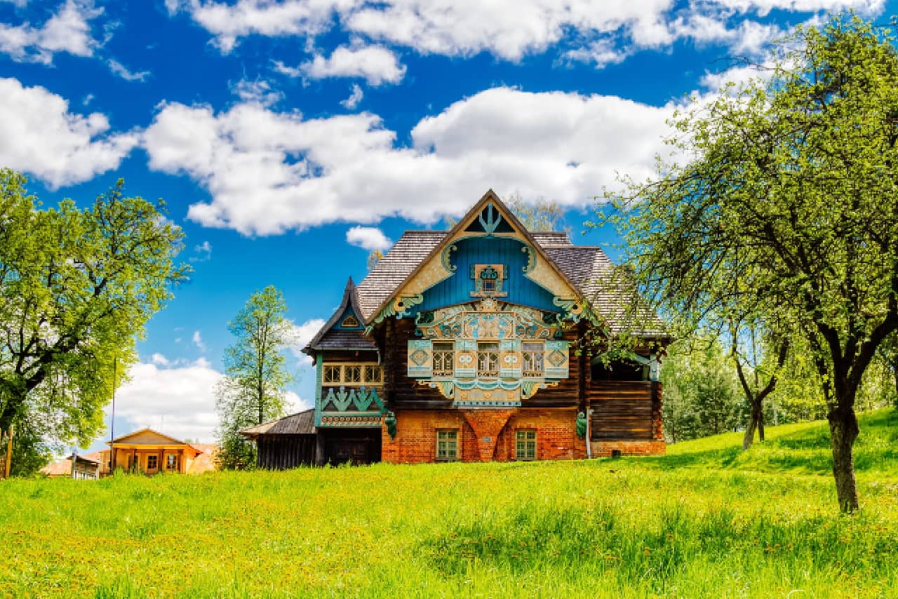 A colorful wooden house in the countryside built in modern style with carved decorations, wooden house from Russian fairytale