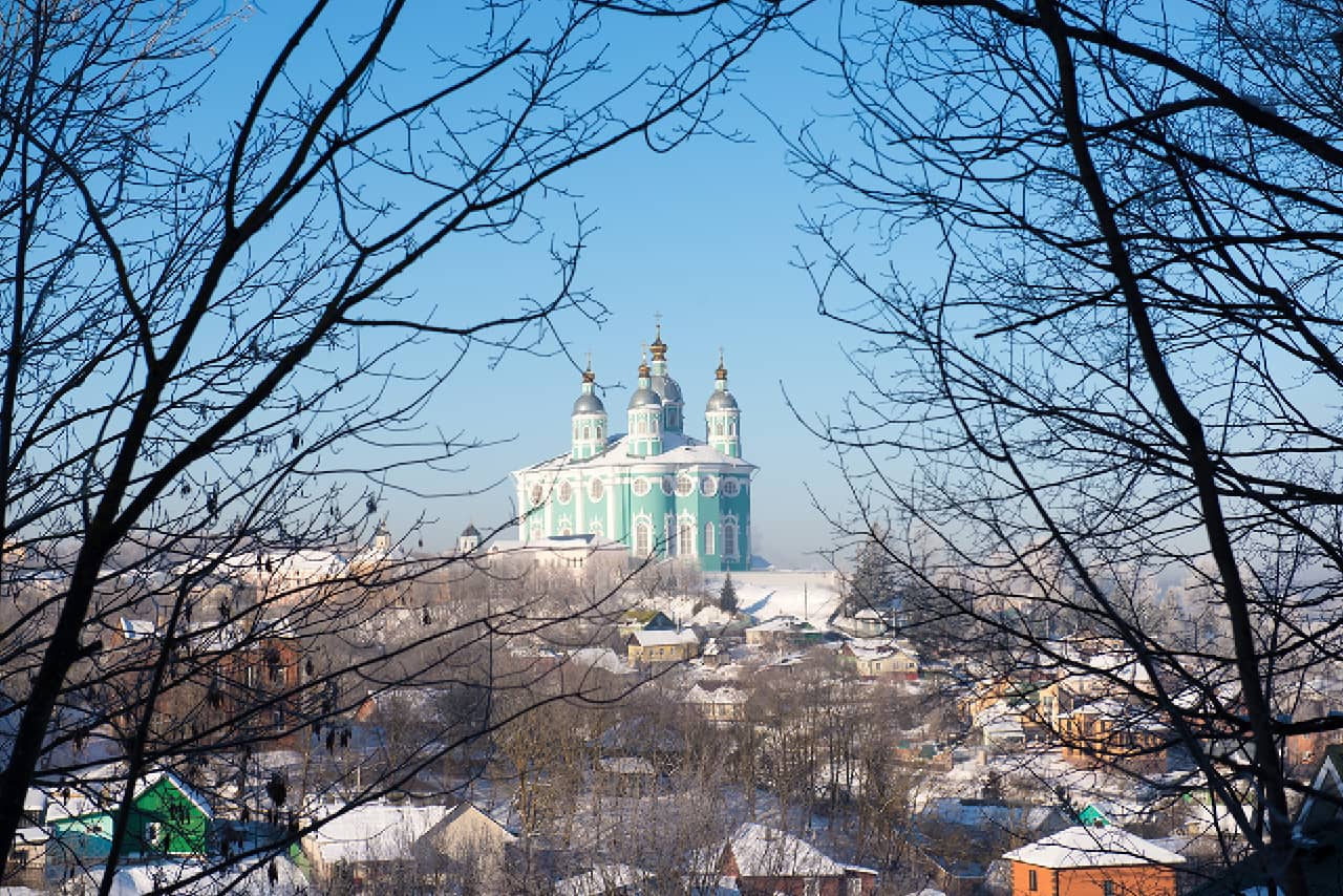 A turquoise and white cathedral in the distance in winter