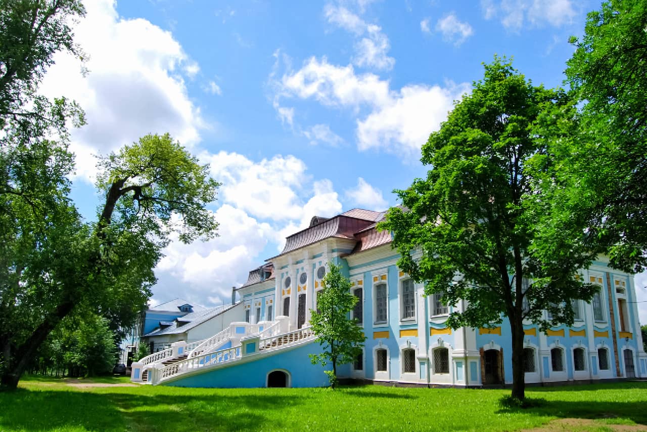 A beautiful noble estate, a blue and white palace with beautiful staircase and green park