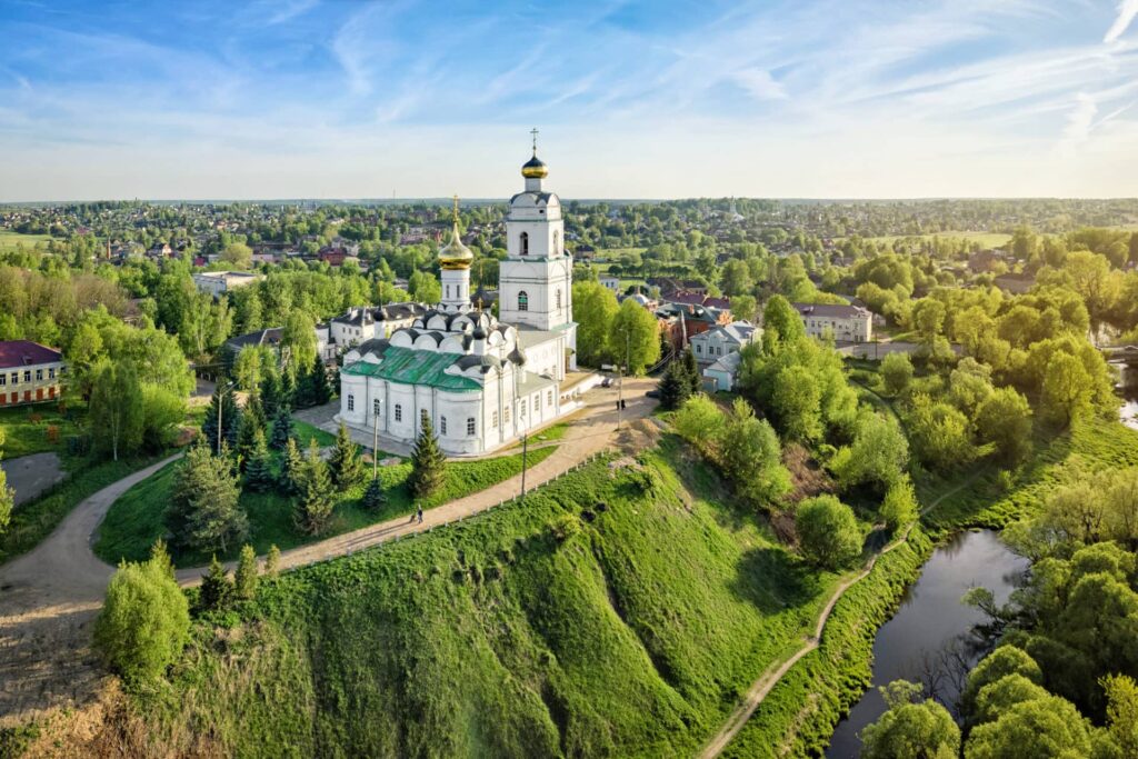 A white Russian orthodox cathedral on the hill near a river
