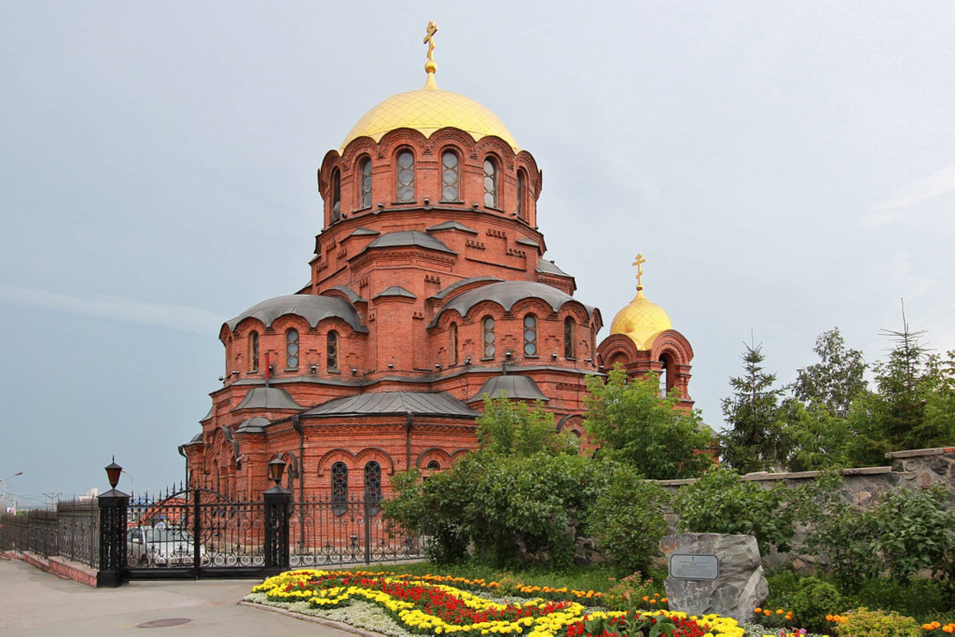 A massive orthodox cathedral of byzantine style made of red brick with gilded domes