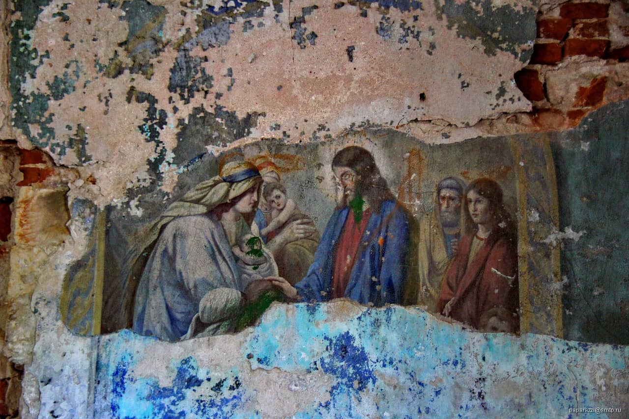 An old fresco in bad condition in a church, a holy image of Jesus and a woman with kid