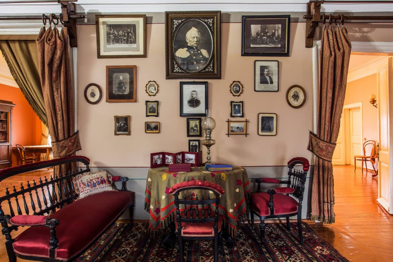 A room with vintage furniture, portraits on the wall, living room of a house of 19th century