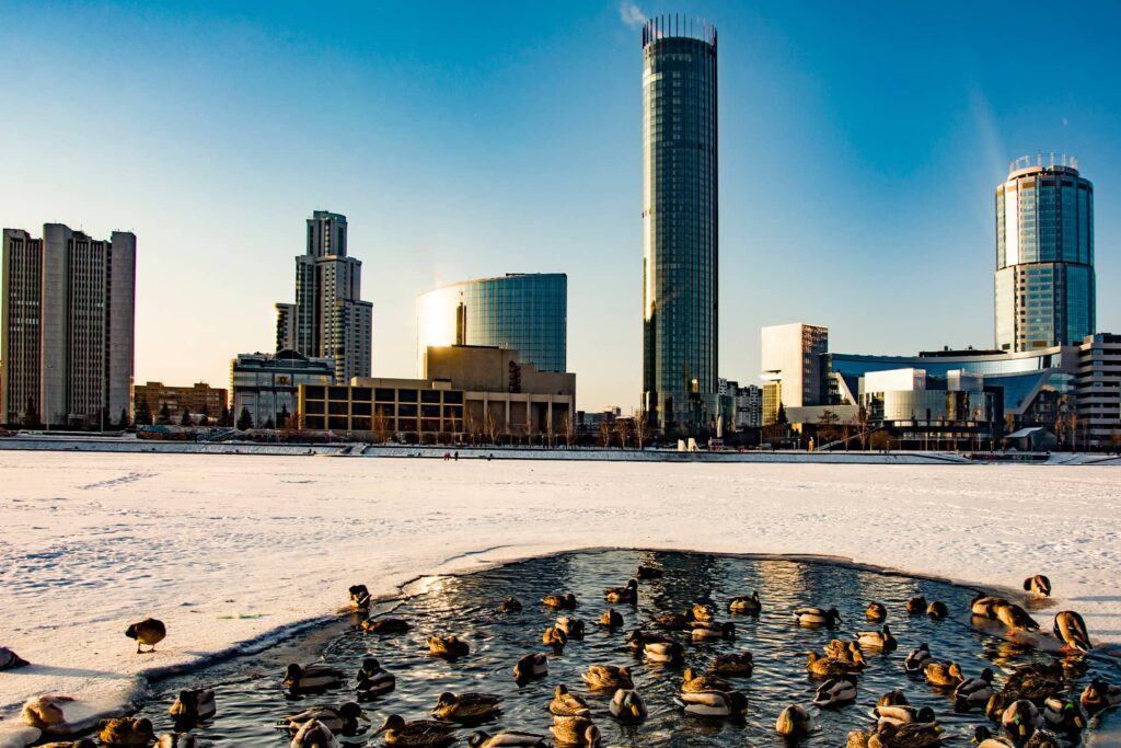 A frozen river and some skyscrapers in the distance