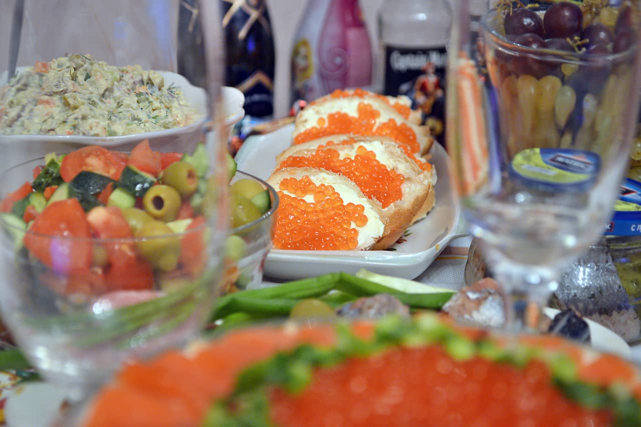 Russian traditional food, sandwiches with red caviar, Russian salad, vegetable salad