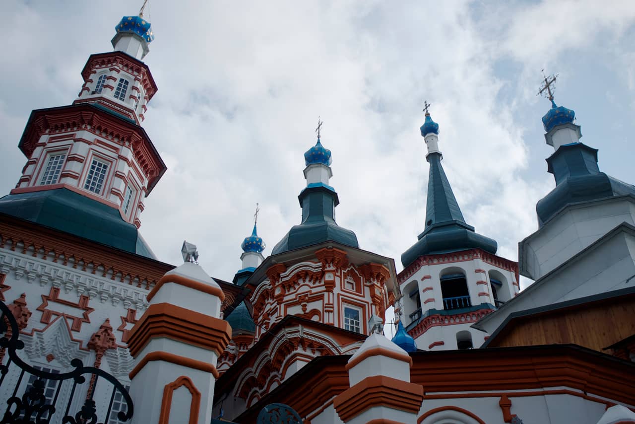 A top of a colorful orthodox church in baroque style, numerous domes of a white and red church