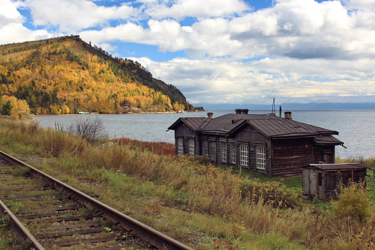 A railway track along the lake, old wooden house near the railway