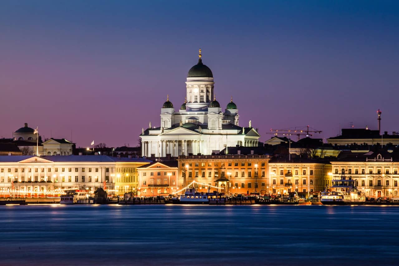 Classical old buildings on the shores of the sea, a massive white cathedral behind the buildings in the evening