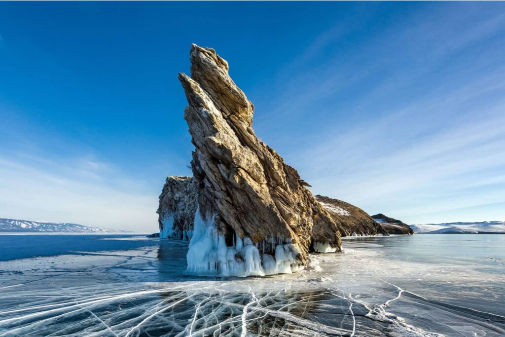 A rock of a shape of a dragon in the middle of frozen lake