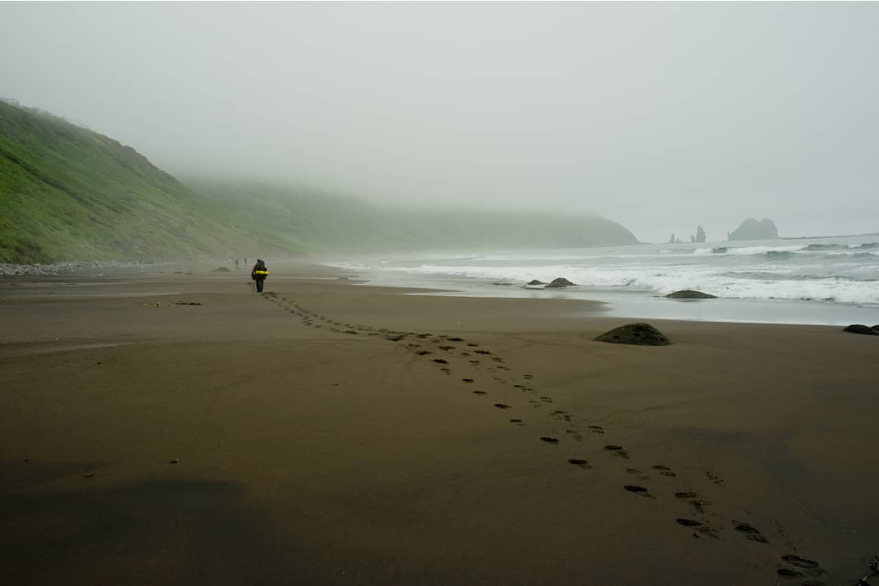 A northern beach in Russia, a man walking on the beach and his footprints