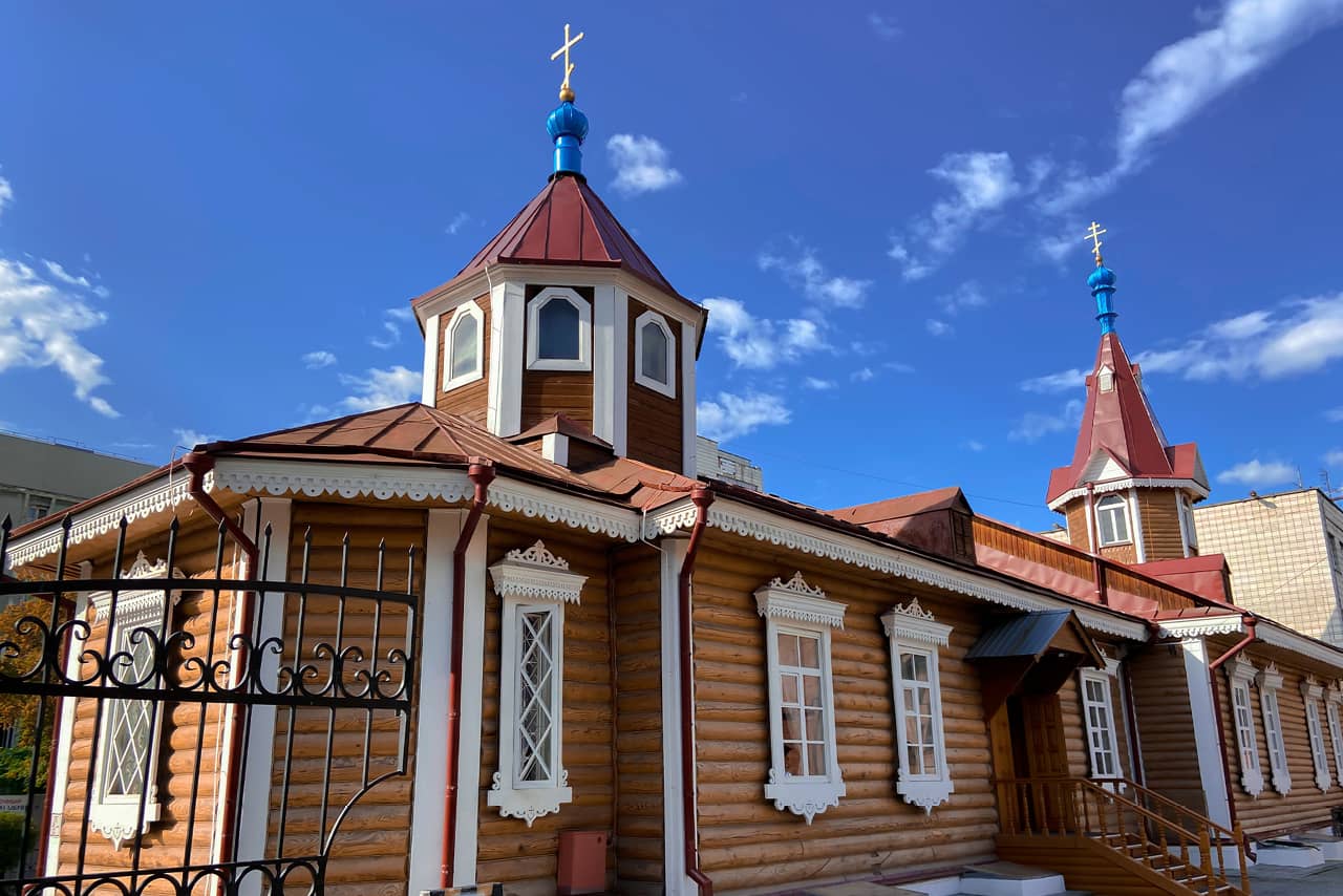A wooden church looking like a Russian izba with white carv