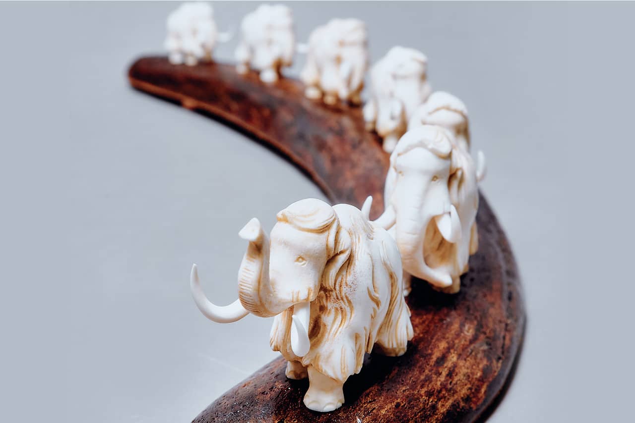 Mammoth figures made of bone on a tusk