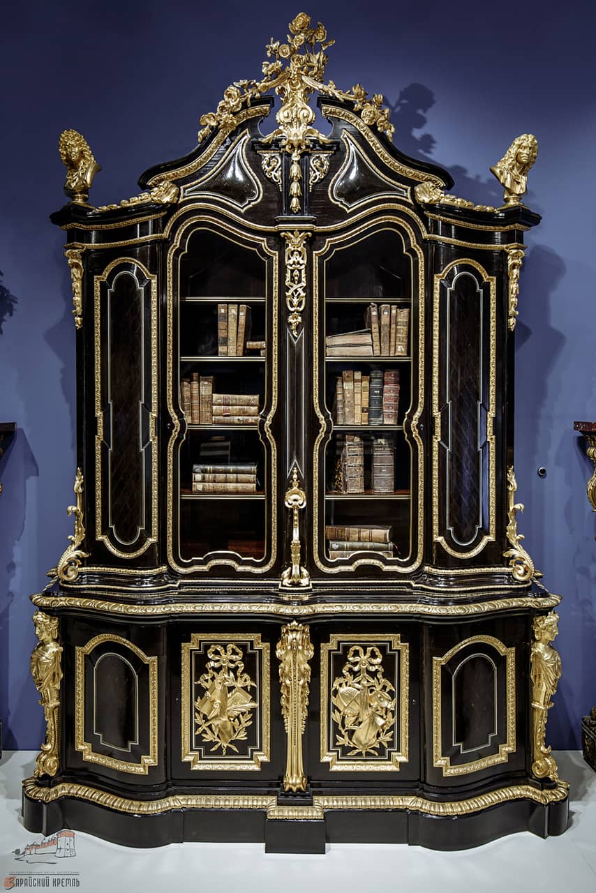 A black wooden cupboard with gilded elements