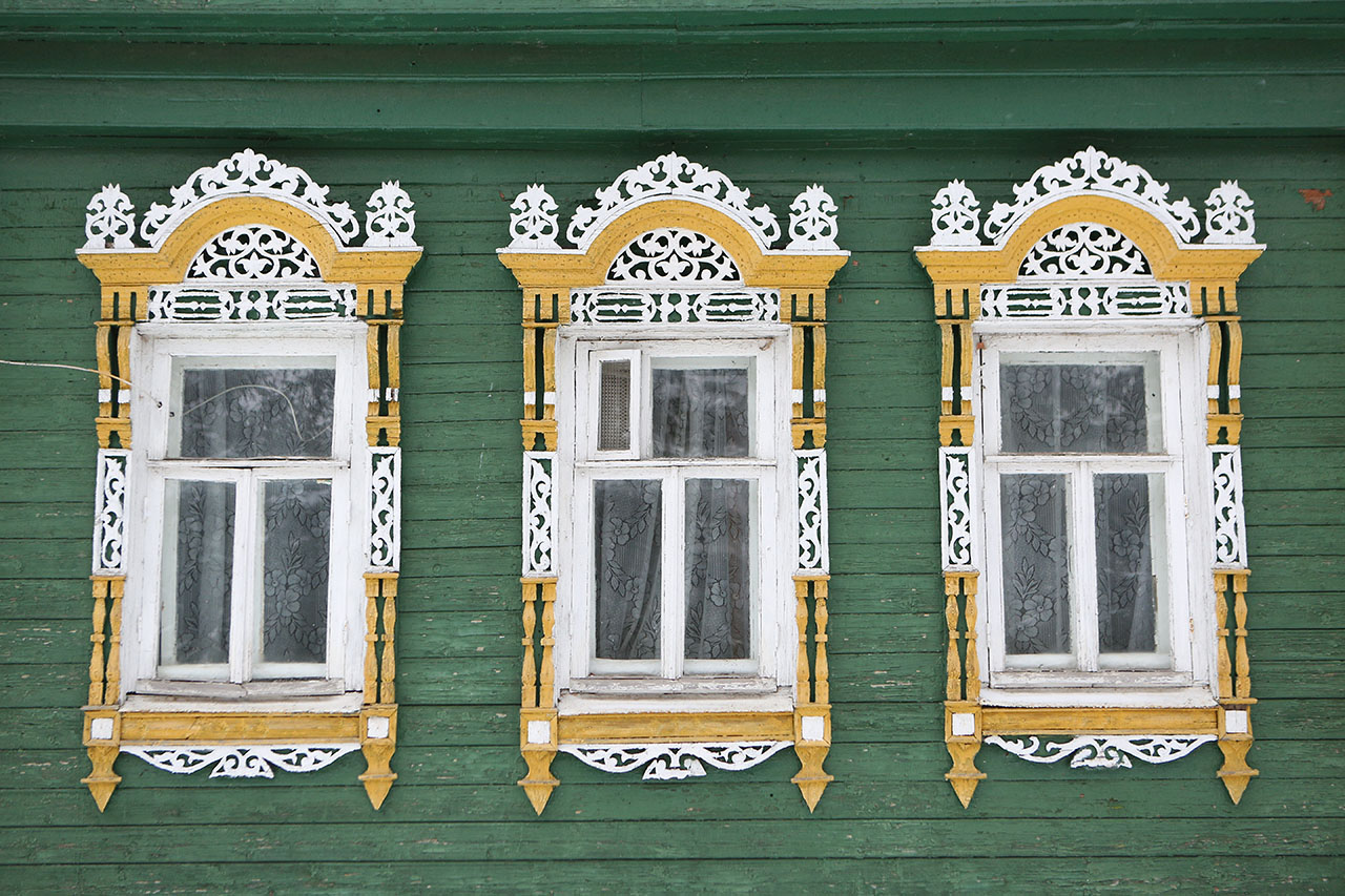 Ornamental windows with carved frames on vintage wooden rural ho